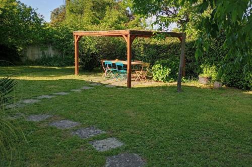 - une table de pique-nique sous un auvent en bois dans une cour dans l'établissement La Villa des Gardies, à Vézénobres