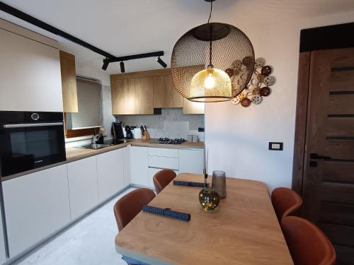 una cocina con mesa de madera y luz eólica en Luxury New Blue moon, en Poreč