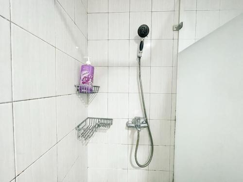 una doccia con una bottiglia viola sul muro di Cozy and Stategic 1 at cikditiro 2BR pool,gym,wifi By LS a Giacarta