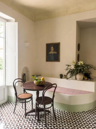 a dining room with a table and chairs and a tub at Torre Perrotti - Le suite in Santa Maria di Castellabate