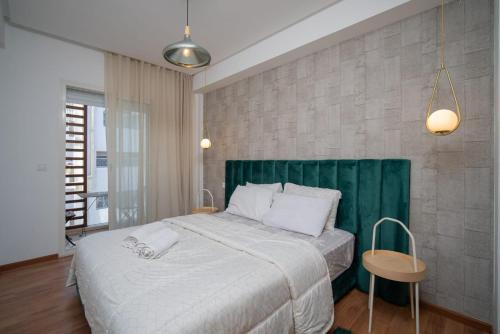 een slaapkamer met een groot bed met een groen hoofdeinde bij studio cosy Maarif stade med V in Casablanca