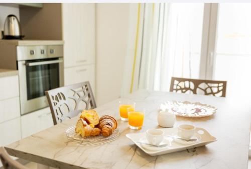 a dining room table with breakfast foods and orange juice at B&B Terre del cretto in Nuova Gibellina