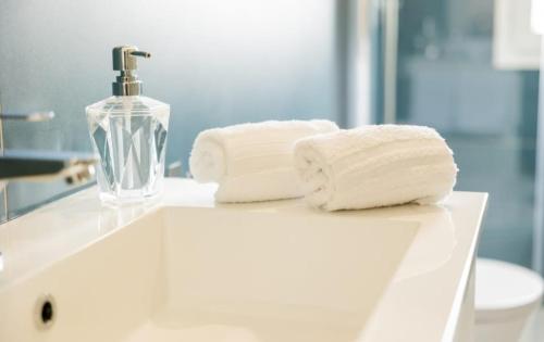 a bathroom sink with two towels and a soap dispenser at B&B Terre del cretto in Nuova Gibellina
