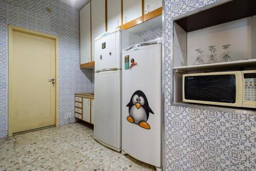 a kitchen with a refrigerator with a penguin on it at Santa Teresa Junto à Natureza in Rio de Janeiro