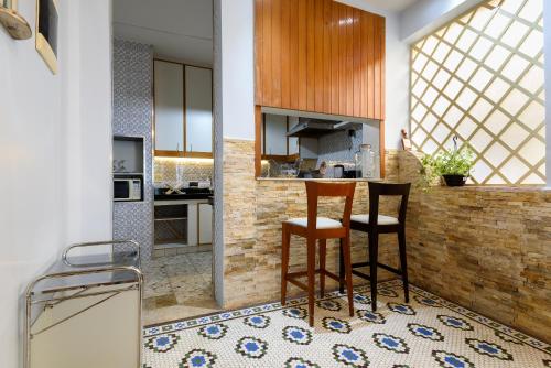 a kitchen with two bar stools and a counter at Santa Teresa Junto à Natureza in Rio de Janeiro