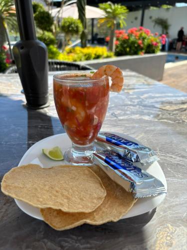 a plate of food with a drink and a plate of bread at Hotel Cinco Diamantes in Atotonilco el Alto