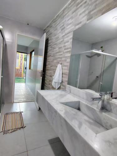 a bathroom with a large sink and a mirror at Aconchegante Casa em Gravatá in Gravatá