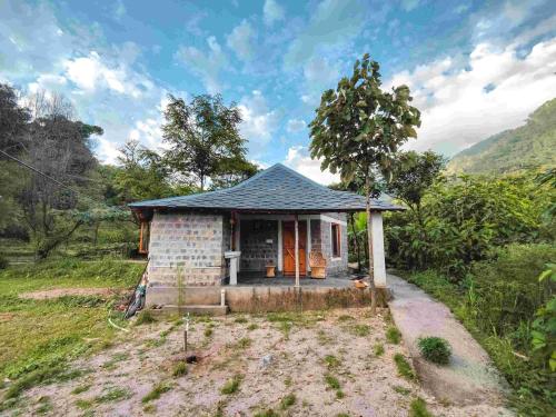 a small house in the middle of a field at Yoga Chaitanya International Institute in Kotla