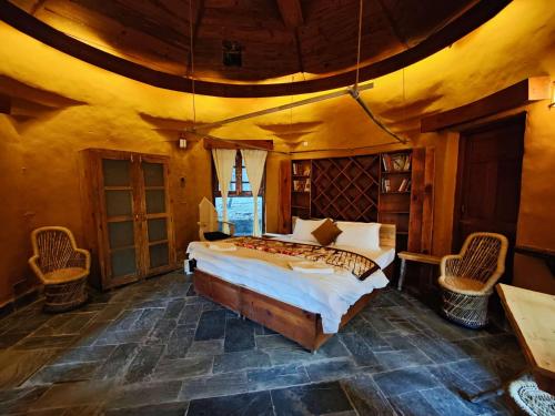 a bedroom with a bed and chairs in a room at Yoga Chaitanya International Institute in Kotla