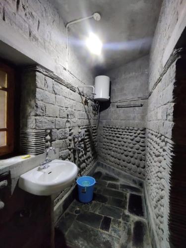 a bathroom with a sink and a stone wall at Yoga Chaitanya International Institute in Kotla