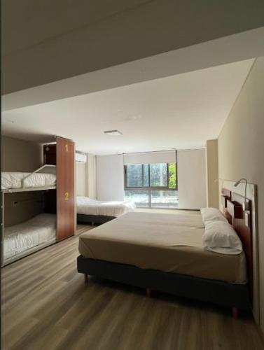 a bedroom with a bed and two bunk beds at Nómade Hostel mdz in Mendoza