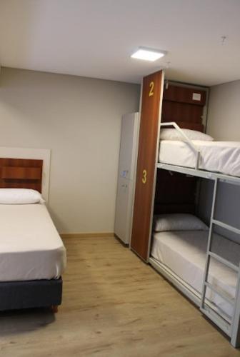 a small room with two bunk beds in it at Nómade Hostel mdz in Mendoza