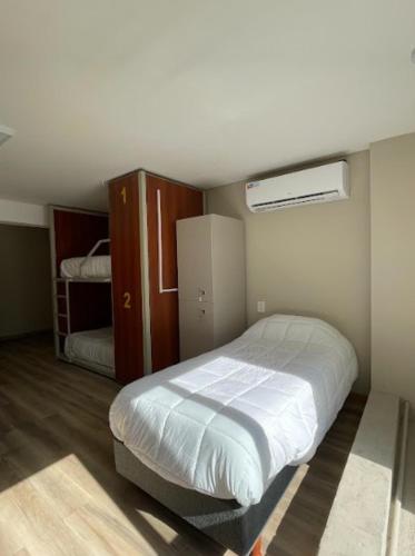 a small bedroom with a bed and a closet at Nómade Hostel mdz in Mendoza