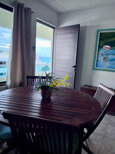 a wooden table with a vase of flowers on it at Great price on the beach in Cancún