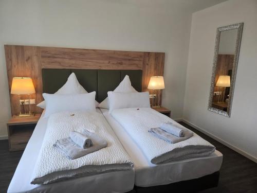 a bedroom with two beds with towels on them at Bodensee Sunshine Zimmer & Apts. in Uhldingen-Mühlhofen