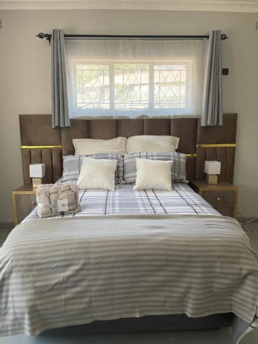 a large bed with two stuffed animals sitting on it at Hulley Homes- Escape to Beautiful Mountain Views in Umtali