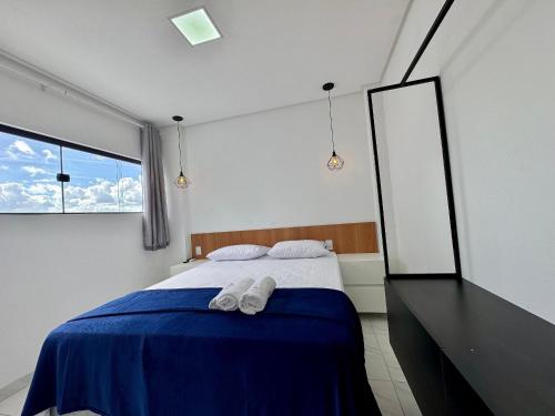 a bedroom with a bed with two white towels on it at Bauten Home Stay Próximo ao Shopping, Centro e Pátio do Forró in Caruaru