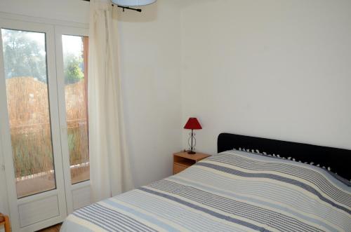 une chambre blanche avec un lit et une fenêtre dans l'établissement Appartement St aygulf bord de mer, à Fréjus
