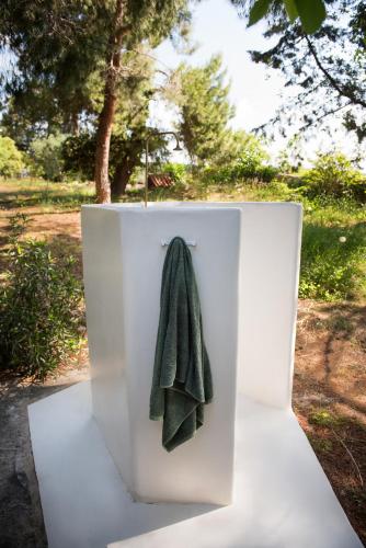 a green towel is hanging on a white wall at Traganitsa in Tragána
