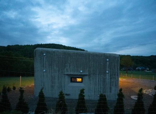 a small building with a window in a field at Bunkier House in Niedźwiada