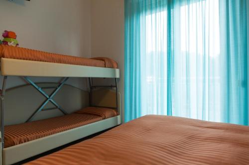 a bedroom with a bunk bed and a window at Hotel Miramare in Pineto