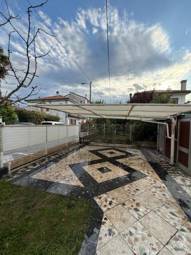 a patio with a white awning in a yard at Casakevauri in Venice
