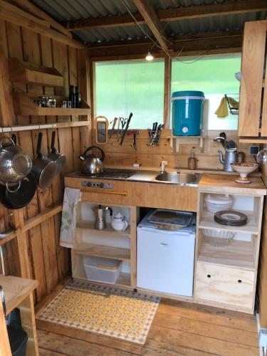 une cuisine avec un évier et une cuisinière dans l'établissement La cabane des Vignes, à Sanssac-lʼÉglise