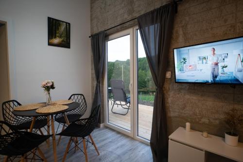 a living room with a table and a sliding glass door at Bunkier House in Niedźwiada