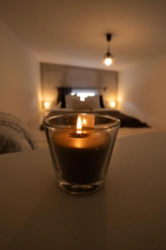 a candle in a glass sitting on a table at Bunkier House in Niedźwiada