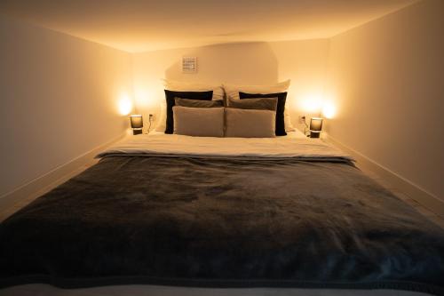 a bedroom with a large bed with two lights on it at Bunkier House in Niedźwiada