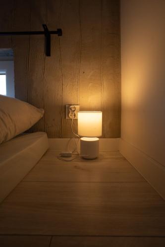 a lamp sitting on the floor next to a bed at Bunkier House in Niedźwiada
