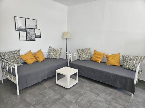 una sala de estar con dos camas y una mesa en Nias Apartments 103, en Keramotí