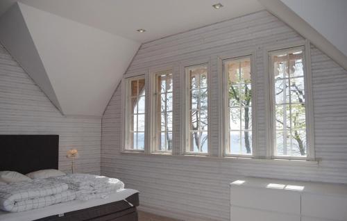 a bedroom with white walls and windows and a bed at Villa Sommarro in Ystad