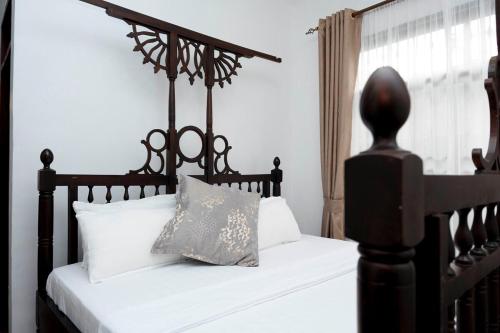a bedroom with a black bed with white pillows at Villa Modern Two Bedroom Vacation home in Mbezi Beach in Dar es Salaam