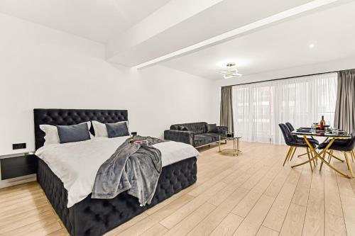 a bedroom with a bed and a couch and a table at InCity Studio - Near Bucharest Mall, Balcony - RH Living in Bucharest