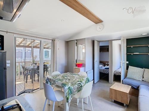 un salon avec une table, des chaises et un canapé dans l'établissement Mobil-home VO 05 à Vias - La Carabasse - Camping Siblu avec Piscine, à Vias