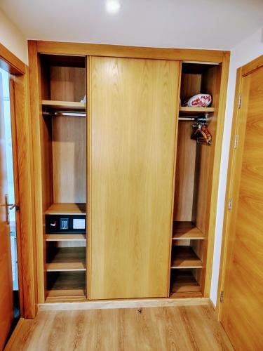 a closet with wooden cabinets in a room at Pensión O Códice by Moradas Nieto in Santiago de Compostela