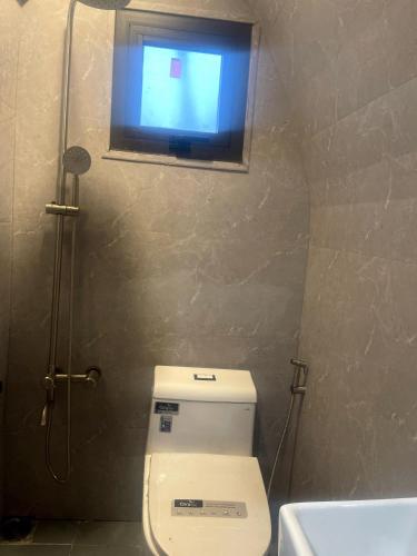 a bathroom with a toilet and a window and a sink at Đông Giang Sky Villa in A Sơ Ră Amo