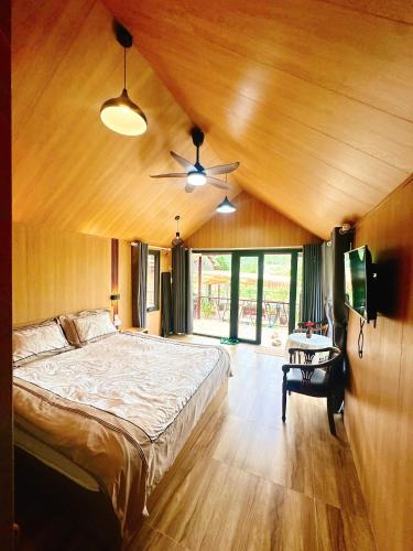 a bedroom with a bed and a ceiling fan at Đông Giang Sky Villa in A Sơ Ră Amo