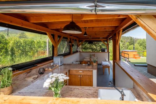 a kitchen in a house with large windows at Orlická přehrada Wellness Chata Hřebeny in Milešov