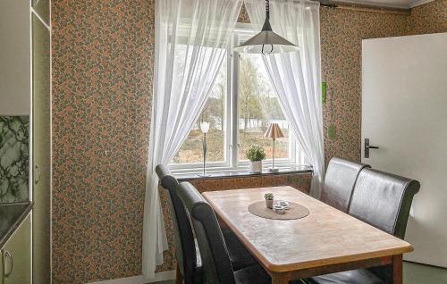 a dining room table with chairs and a window at Mården in Fegen