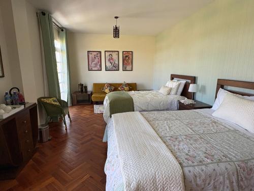 a hotel room with two beds and a couch at Casa Deco Hotel Boutique in Cochabamba