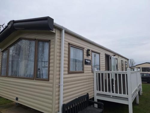 a mobile home with a porch and a black bench at Lunas Seaside Haven in Corton