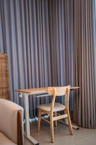 a wooden table and a chair next to a curtain at Palase Elite Villas in Himare
