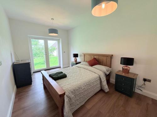 a bedroom with a large bed and a window at Spacious 4 double bed rural escape in Duddlestone