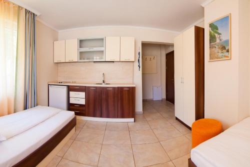 ein kleines Zimmer mit 2 Betten und einer Küche in der Unterkunft Guest House Hiora in Achtopol