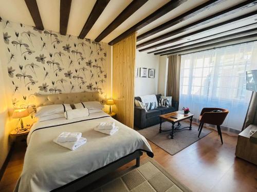 une chambre avec un grand lit et un salon dans l'établissement Studio chic de Sophie plein cœur du centre-ville, à Honfleur