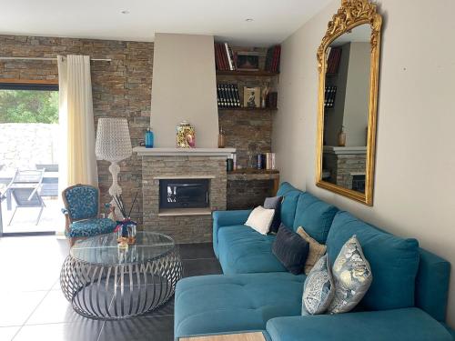 un salon avec un canapé bleu et une table en verre dans l'établissement Belle villa avec piscine, à Borgo