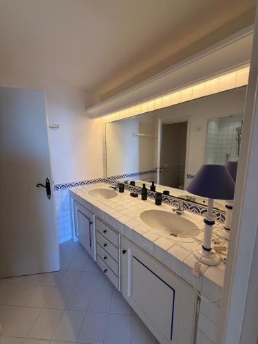 une salle de bain avec deux lavabos et un grand miroir dans l'établissement Villa Provençale de Charme avec Piscine et Vue mer, à Sainte-Maxime