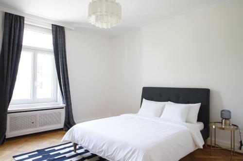 a bedroom with a white bed and a window at ReLiving in Luzern
